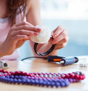 Kadın evde mücevher yapıyor.