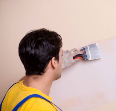 Duvara alçı yapıştıran genç müteahhit.