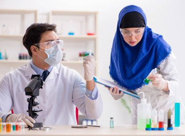 Laboratuvarda çalışan iki kimyager.