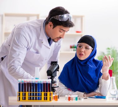Laboratuvarda çalışan iki kimyager.