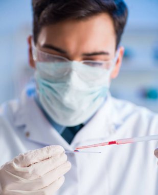 Laboratuvar asistanı hastanede kan örneklerini test ediyor.
