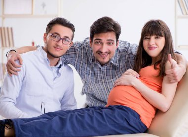 Hamile kadın kocasıyla klinikteki doktoru ziyaret ediyor.