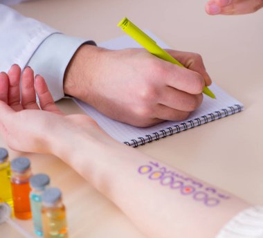 Hastanedeki hastanın alerji reaksiyonunu test eden doktor.