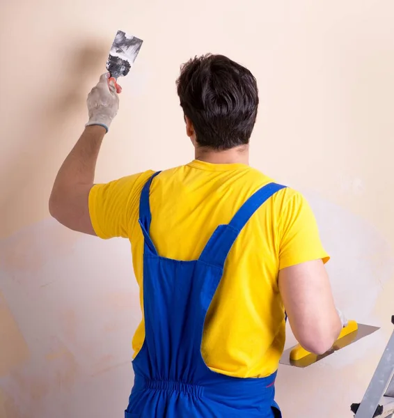 Empleado joven contratista aplicando yeso en la pared —  Fotos de Stock