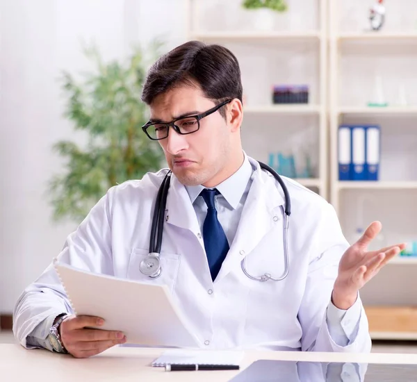 Junger Arzt sitzt im Büro — Stockfoto