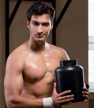 Spor salonunda besin takviyesi olan bir adam.