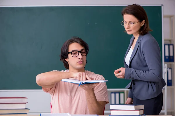 Velha professora e estudante do sexo masculino na sala de aula — Fotografia de Stock