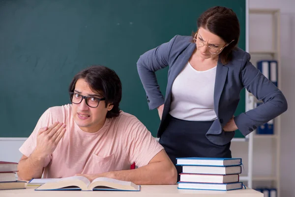 Velha professora e estudante do sexo masculino na sala de aula — Fotografia de Stock