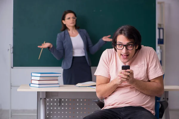 Velha professora e estudante do sexo masculino na sala de aula — Fotografia de Stock