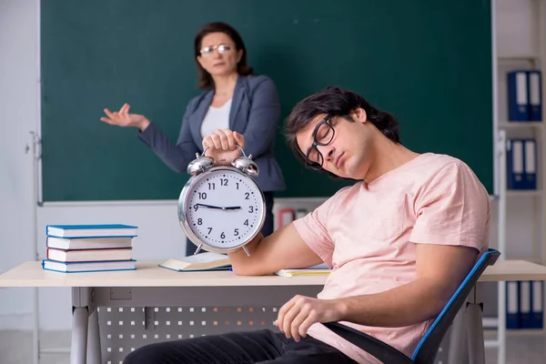 Oude vrouwelijke leraar en mannelijke student in de klas — Stockfoto