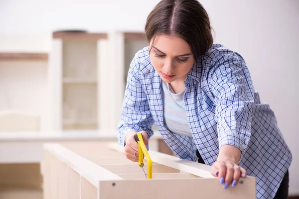 Joven hermosa mujer ensamblando muebles en casa — Foto de Stock