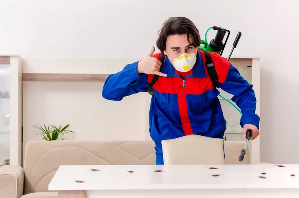 Jovem empreiteiro fazendo controle de pragas em casa — Fotografia de Stock