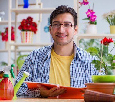 Çiçekçide çalışan genç bir adam.