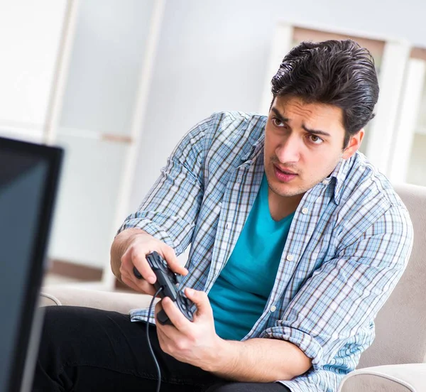 Мужчина играет в компьютерные игры дома — стоковое фото