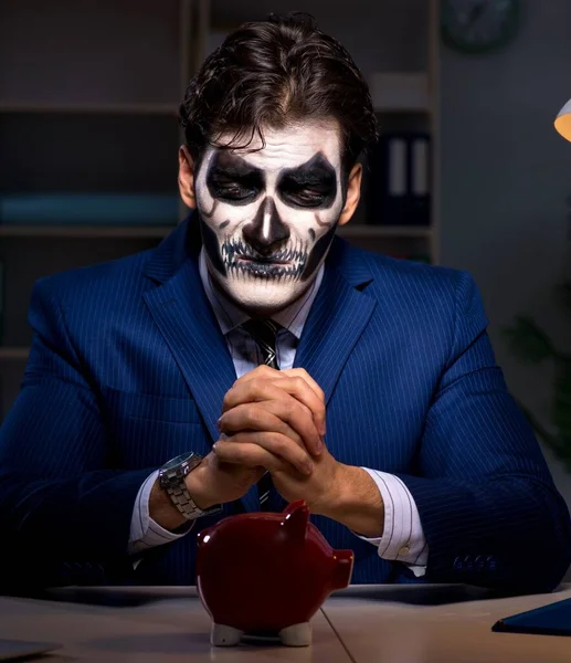 Obchodník se strašidelnou maskou pracuje dlouho do noci v kanceláři. — Stock fotografie