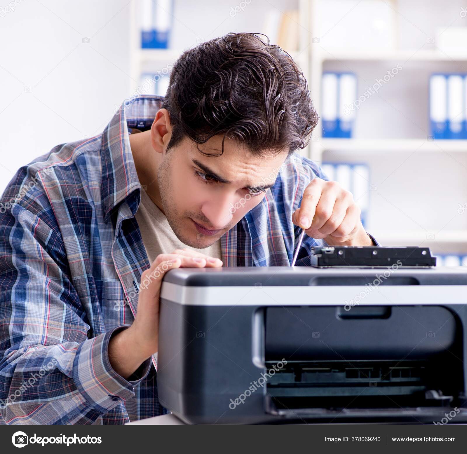 Hardware repairman repairing broken printer fax machine Stock Photo by