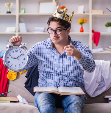 Genç adam dağınık bir odada çalışıyor.