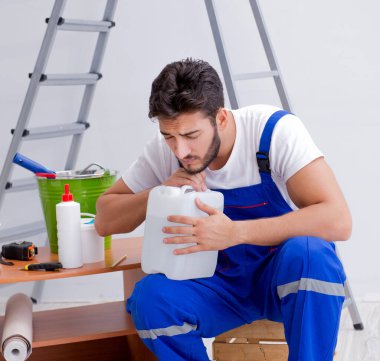 Tamirci, duvar kağıdıyla evde tadilat yapıyor.