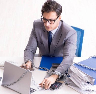 Ofis masasına zincirlenmiş meşgul bir çalışan.