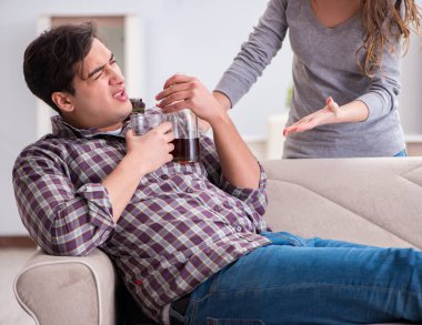 Genç bir aile kavramında içki sorunu yaşayan sarhoş bir koca.