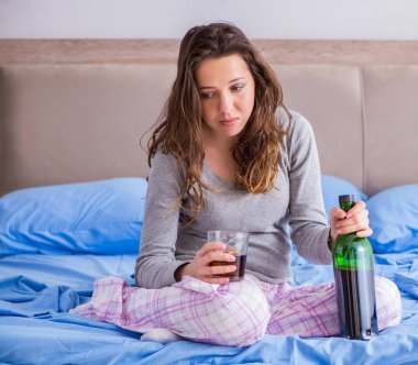 Evde alkol alan genç bir kadın depresyonda.