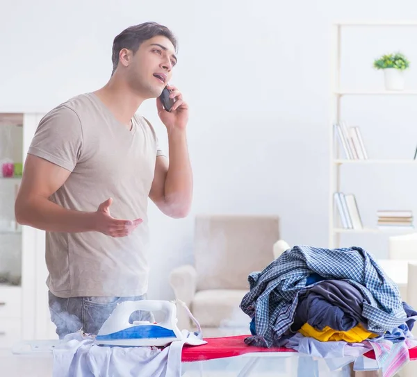 O marido desatento queima roupas enquanto passa a ferro — Fotografia de Stock