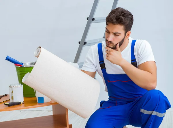 Reparador haciendo reparación de renovación en la casa con wallpa de papel —  Fotos de Stock