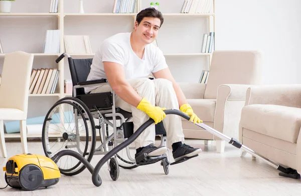 Uomo disabile con aspirapolvere a casa — Foto Stock