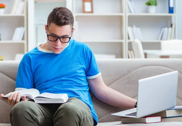 Jonge student bereidt zich voor op examens thuis studeren op een bank — Stockfoto