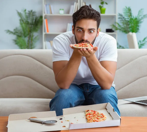 Hombre comiendo pizza teniendo una comida para llevar en casa descansando relajado — Foto de Stock