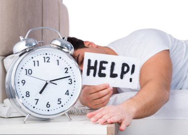 Yatakta uykusuzluk çeken bir adam.