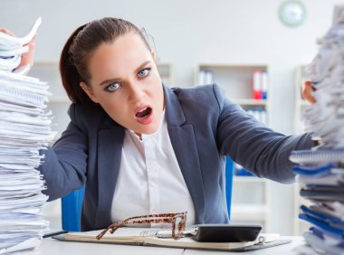 Evrak işleriyle uğraşan yorgun bir iş kadını.