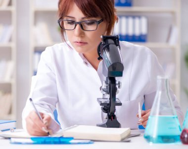 Bir laboratuarda deney yapan kadın bir bilim adamı.