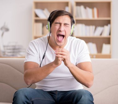 Evde müzik dinleyen bir adam.