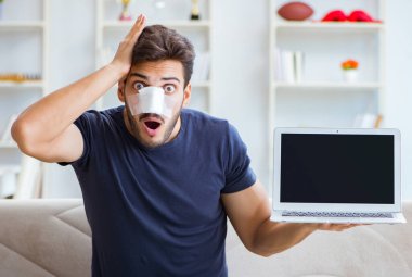 Genç adam estetik cerrahi burnundan sonra evde iyileşiyor.