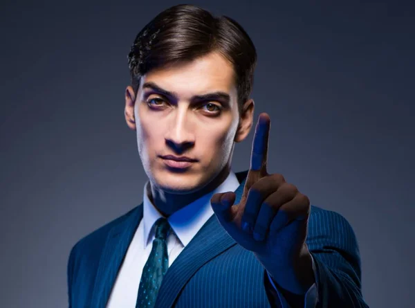 灰色の背景に仮想ボタンを押すビジネスマン — ストック写真