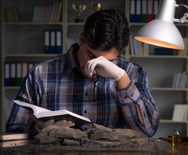 Arkeolog geç saatlere kadar ofiste çalışıyor.