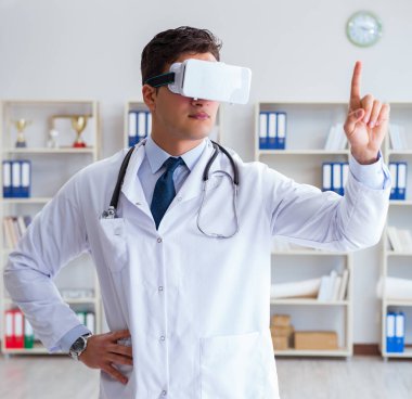 Sanal gerçeklik kulaklığı olan genç doktor ofiste çalışıyor.