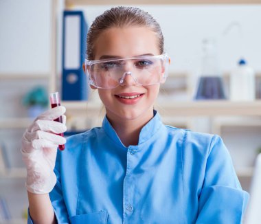 Bir laboratuarda deney yapan kadın bir bilim adamı.