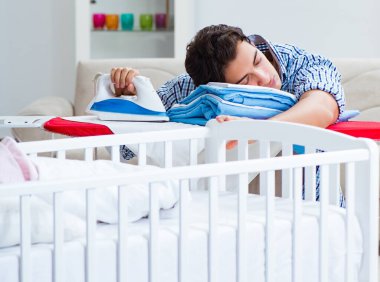 Genç baba yeni doğan bebeğe bakıyor.