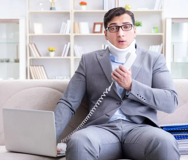 Man in neck brace cervical collar working from home teleworking