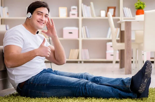 El joven estudiante escuchando música en casa —  Fotos de Stock