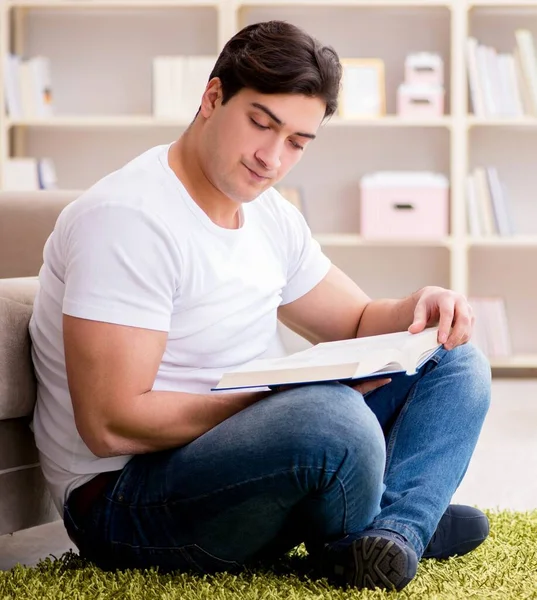 Hombre leyendo libro en casa en el suelo — Foto de Stock