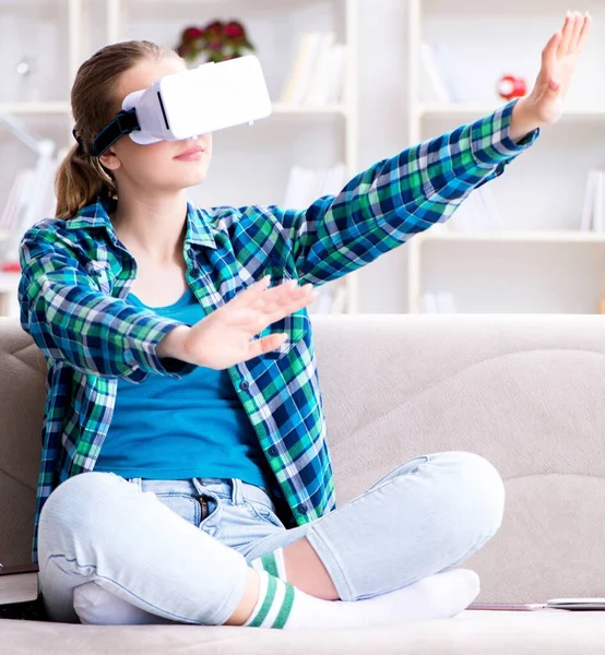 Vrouwelijke student zittend op de bank met virtuele bril — Stockfoto