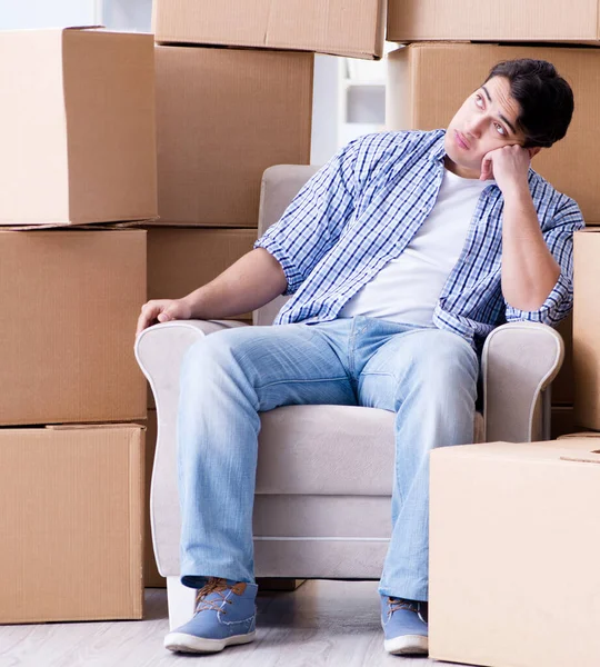 Young man moving in to new house with boxes — Stock Photo, Image