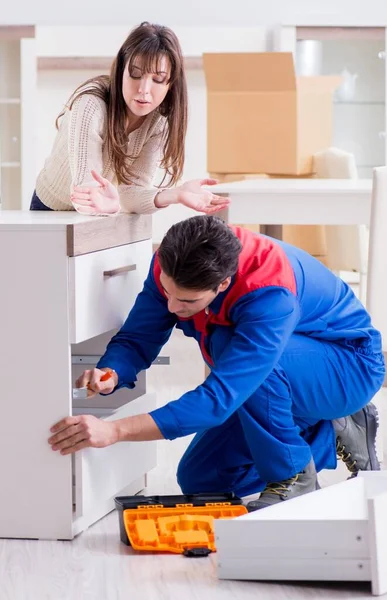 Contractor repairman assembling furniture under woman supervisio — Stock Photo, Image