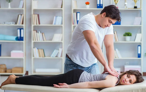 Jovem médico quiroprático massageando mulher paciente — Fotografia de Stock