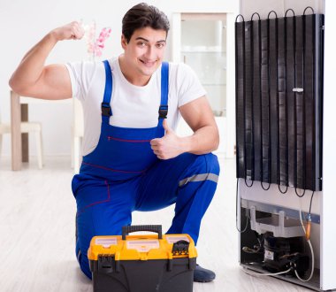Tamirci müteahhit DIY konseptinde buzdolabını tamir ediyor.