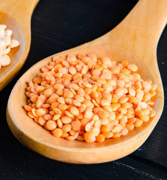 The spoons filled with uncooked lentil for soup — Stock Photo, Image