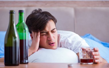 Man alcoholic drinking in bed going through break up depression clipart